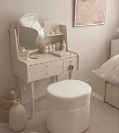 a white dressing table and stool in a bedroom