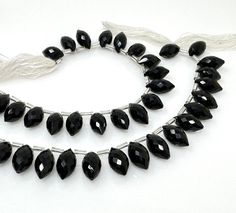 a necklace with black glass beads on a white background