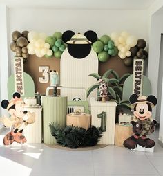 a mickey mouse birthday party with balloons and decorations