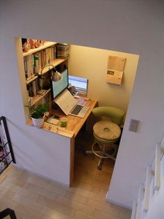 an open laptop computer sitting on top of a wooden desk next to a book shelf