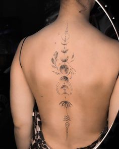 the back of a woman's body with tattoos on her upper and lower back