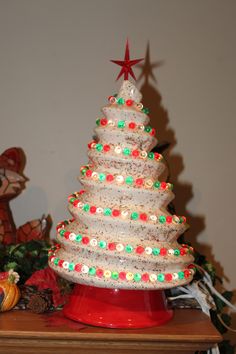 a lighted christmas tree sitting on top of a wooden table next to a teddy bear