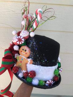 a black hat with candy canes and a gingerbread man on the top it