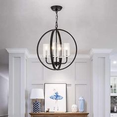 a living room filled with furniture and a chandelier hanging over a fire place