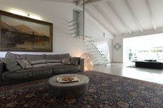 a living room with a couch, coffee table and stairs