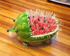 a watermelon with spikes in the shape of a hedgehog sitting on top of it