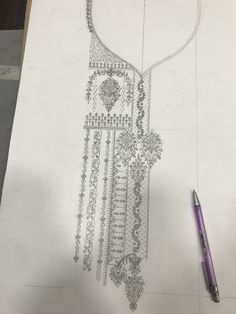 a drawing of a necklace on paper with a pen