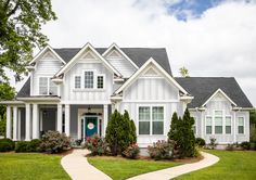 a large house with white trim and gray sidings on the front door is shown