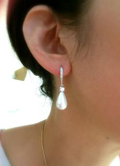 a close up of a person wearing some kind of earring with pearls on it