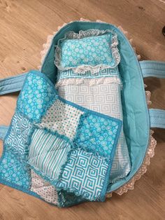 the inside of a blue and white bag with several pieces of fabric in it on top of a wooden floor