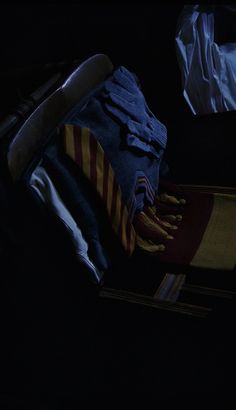 an open suitcase filled with clothes in the dark