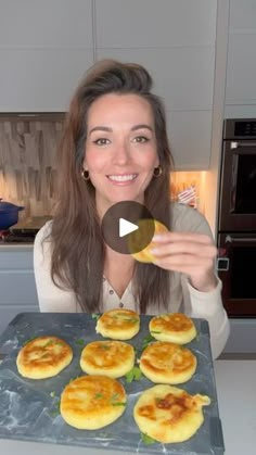 a woman holding up a tray with food on it