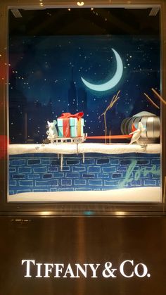 a display window with an image of a boat and other items in the water at night