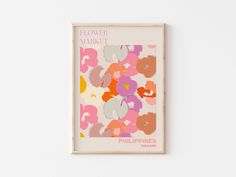 a flower market poster hangs on the wall in front of a white wall with pink, orange and yellow flowers