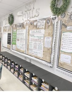 a classroom with several bulletin boards and wreaths on the wall above them, along with bookshelves