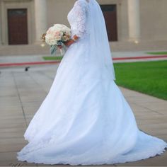 a woman in a white wedding dress holding a bouquet