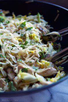 a bowl filled with noodles and vegetables on top of a table