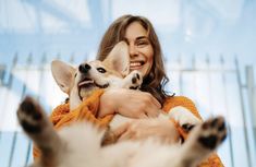 a woman holding two small dogs in her arms