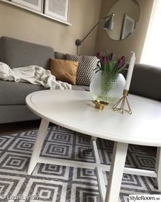 a living room with a gray couch and white table