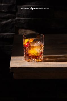 a glass filled with liquid sitting on top of a wooden table