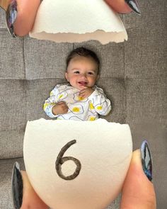 a baby sitting on top of a white object