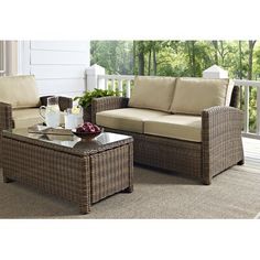 an outdoor patio furniture set with wicker couches and coffee table on the porch