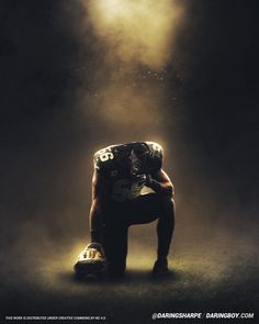 a football player kneeling down with his head on his knees in the foggy dark