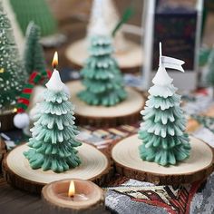 small candles are sitting on wood slices in the shape of christmas trees with white frosting