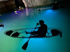 a man in a kayak floating on top of a body of water next to other boats