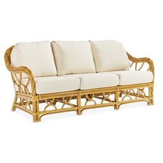 a wicker couch with white cushions on it's back and arms, in front of a white background