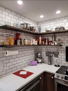 a kitchen filled with lots of white counter top next to a stove top oven and microwave