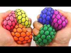 two hands holding three different colored balls in each hand, one is multicolored and the other is black