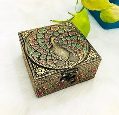 a decorative box sitting on top of a white fur covered floor next to a plant