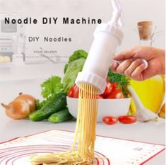 a hand is pouring pasta into a white bowl with vegetables and olives in the background