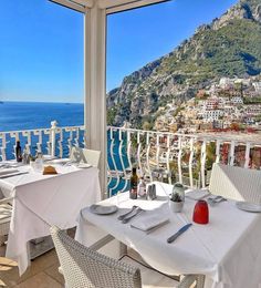 an outdoor dining area with tables and chairs overlooking the ocean in positi, italy