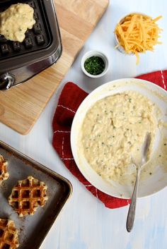 some waffles and cheese are on a table next to a bowl of dip