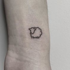 a small black sheep tattoo on the wrist