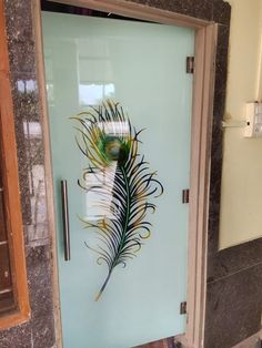 a glass door with a decorative peacock feather on it