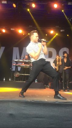 a man standing on top of a stage holding a microphone