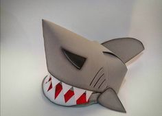 an origami shark with red and white stripes on it's mouth is shown