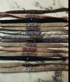 several different types of hair ties laid out on a marble counter top with beads and sequins