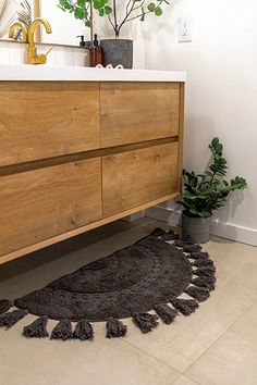 a bathroom with a yellow rug on the floor next to a wooden cabinet and sink