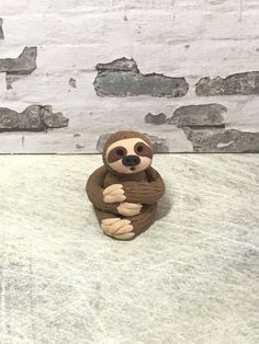 a small stuffed sloth sitting on top of a table