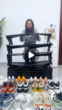 a woman sitting on top of a pile of shoes in front of a tv screen