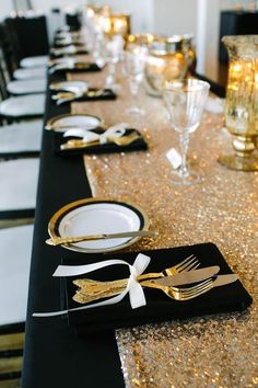 the table is set with black and gold place settings