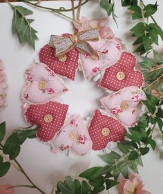 a wreath made out of fabric with buttons and flowers around it on a white surface