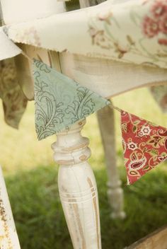 the table cloths are hanging from the top of the wooden structure in the yard