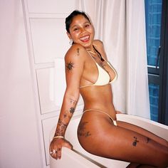 a woman with tattoos sitting on a toilet