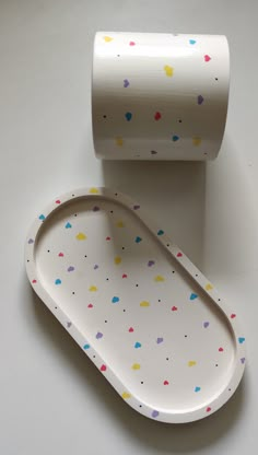 a white plate with colorful confetti on it next to a roll of toilet paper