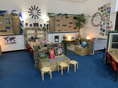 a room filled with lots of furniture and walls covered in cardboard boxes on top of blue carpeted flooring